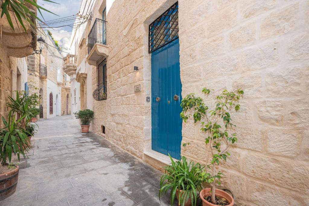 uma porta azul ao lado de um edifício com plantas em Casa Melita em Rabat