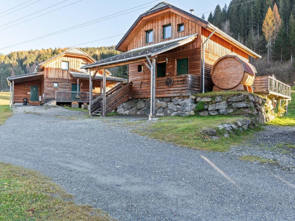 a large wooden house with a large wooden barrel at Chalet in St Georgen ob Murau with sauna in Sankt Georgen ob Murau