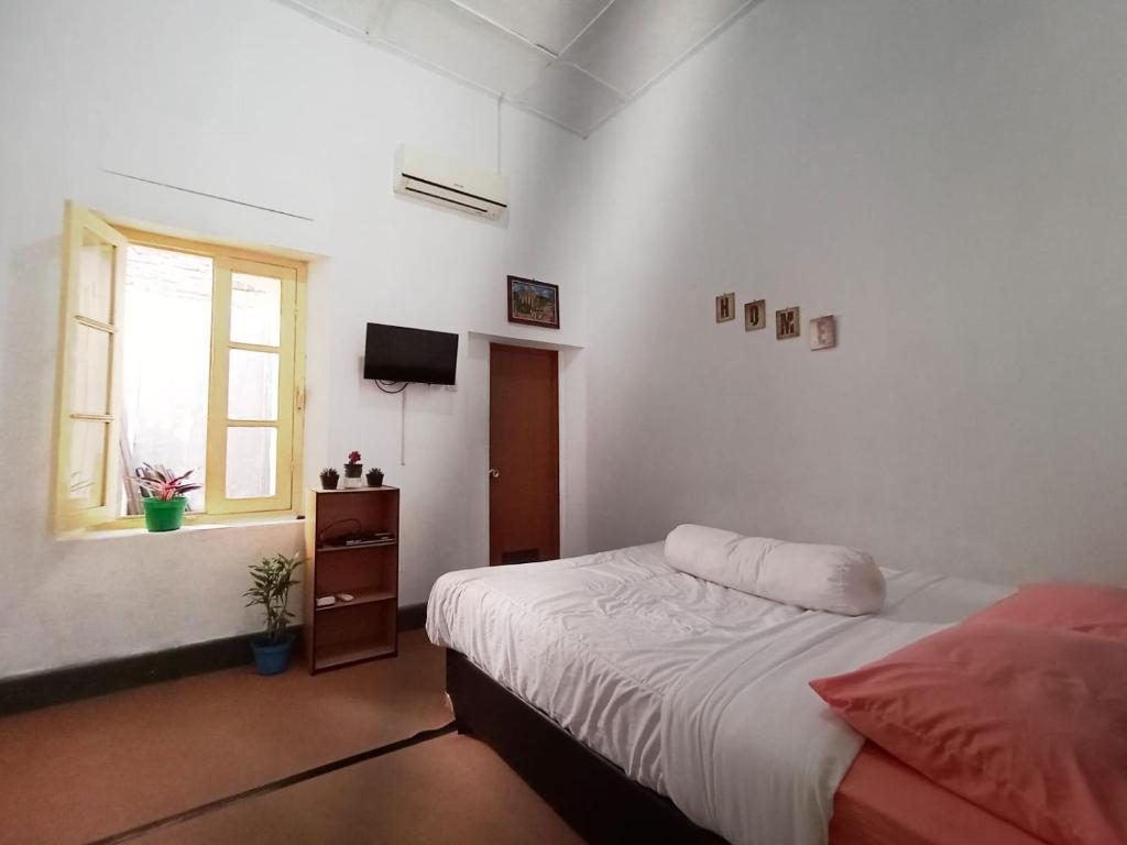 Schlafzimmer mit einem Bett und einem Fenster in der Unterkunft Brak Homestay in Sukobumi