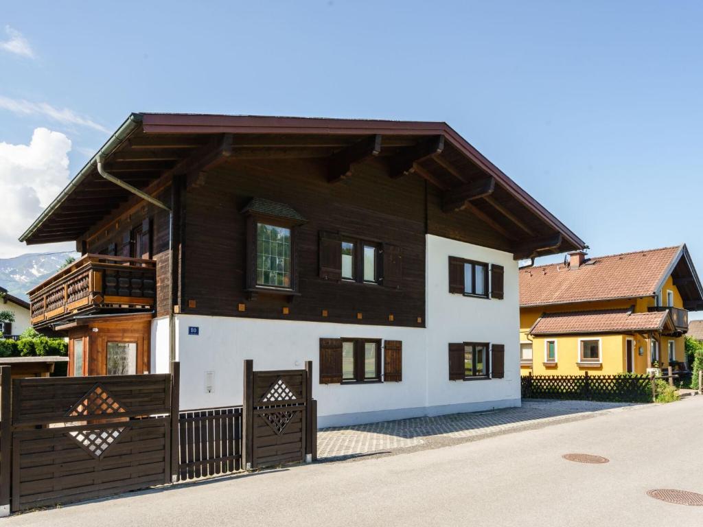 a brown and white house with a gate at Holiday home near Zell am See and Kaprun in Bruck an der Großglocknerstraße