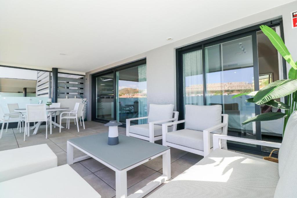 salon z białymi krzesłami i stołem w obiekcie Brand new luxury apartment in Cala Serena w mieście La Cala de Mijas
