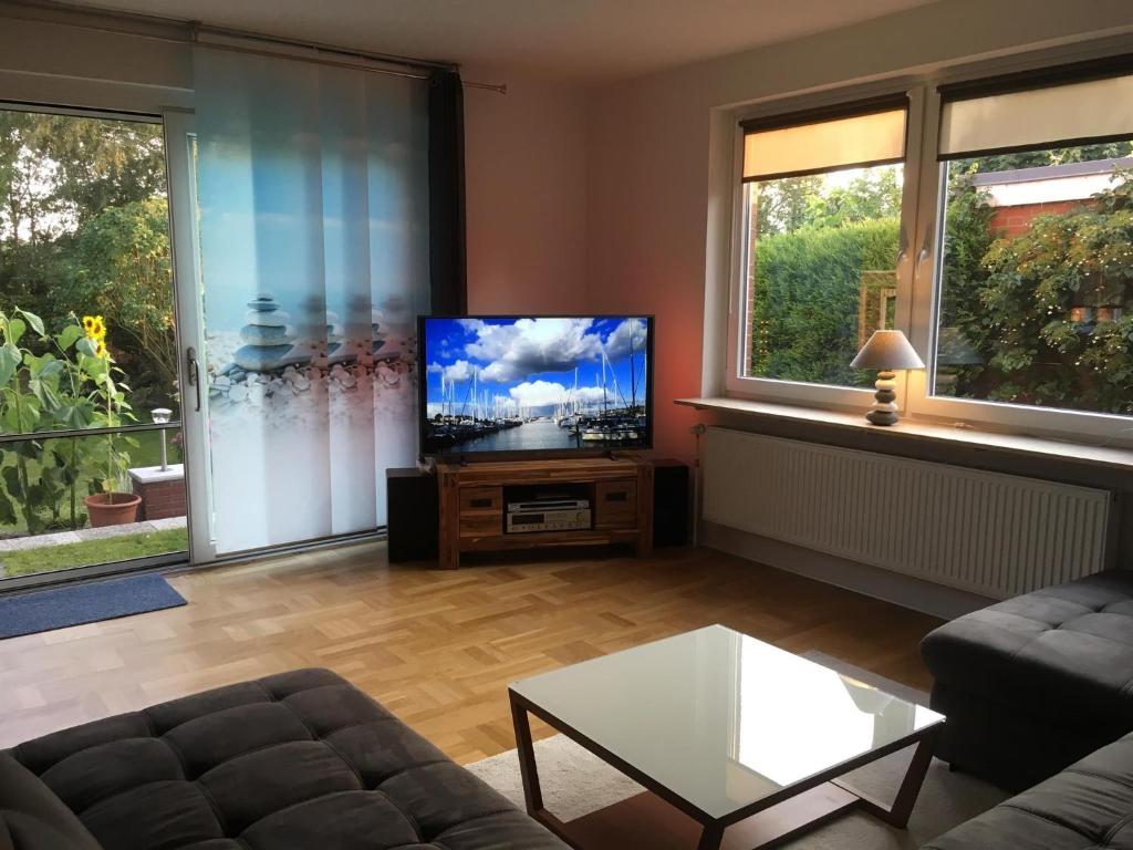 a living room with a couch and a flat screen tv at Ferienwohnung Kajüte in Wees