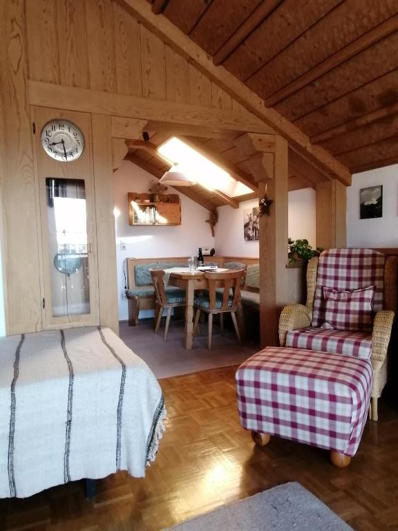 a room with a table and chairs and a clock at Ferienwohnung Soyer in Sonthofen