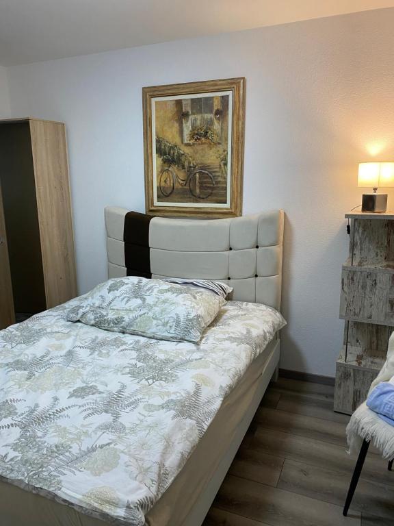 a bed in a room with a picture on the wall at Plein soleil in Martigny-Ville