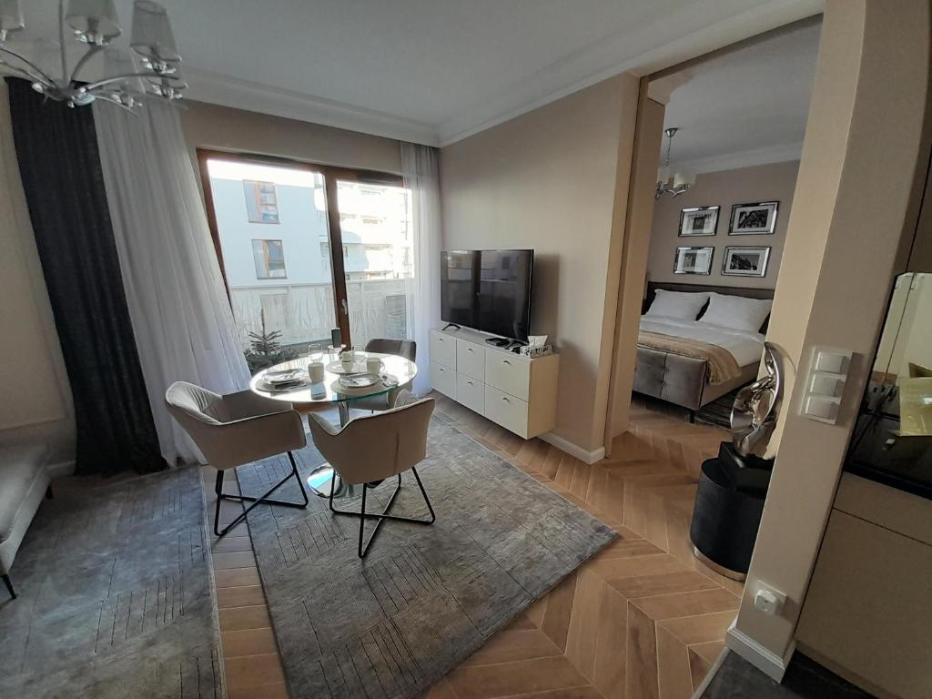 sala de estar con mesa y dormitorio en Beige MOOD City Apartment, en Wroclaw
