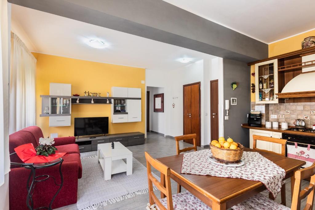 a kitchen and a living room with a table and a couch at La casa di Marta in Noto
