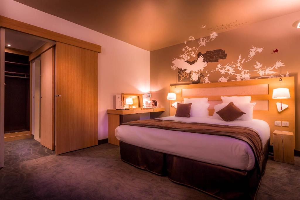 a bedroom with a large bed in a room at Le Grand Aigle Hotel & Spa**** in La Salle-les-Alpes