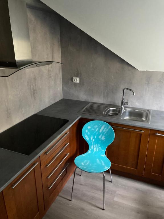 a blue chair sitting in a kitchen next to a sink at Downtown Historical House with Renovated apartments in Ålesund