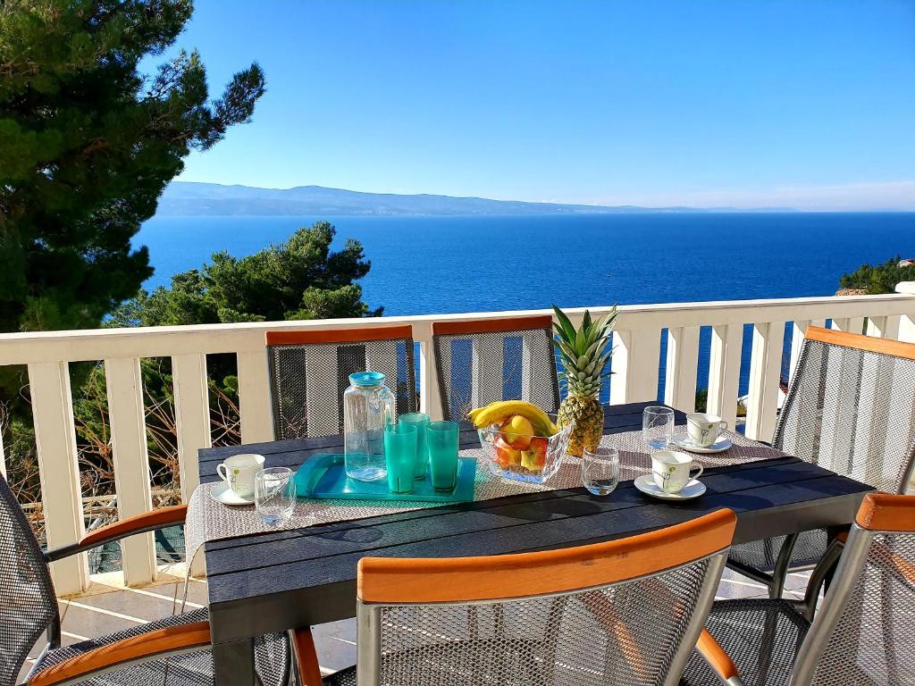 een blauwe tafel op een balkon met uitzicht op de oceaan bij VILLA BLUE ADRIATIC in Stanići