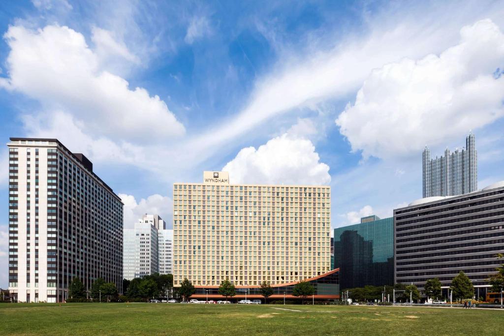 um horizonte da cidade com edifícios altos e um campo em Wyndham Grand Pittsburgh em Pittsburgh