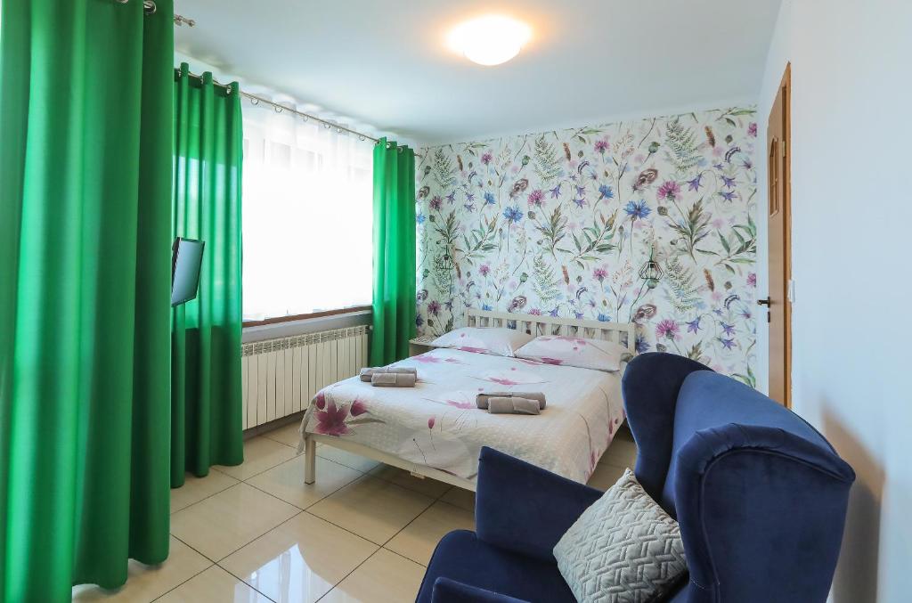 a small bedroom with a bed and a chair at Apartamenty Częstochowa in Częstochowa