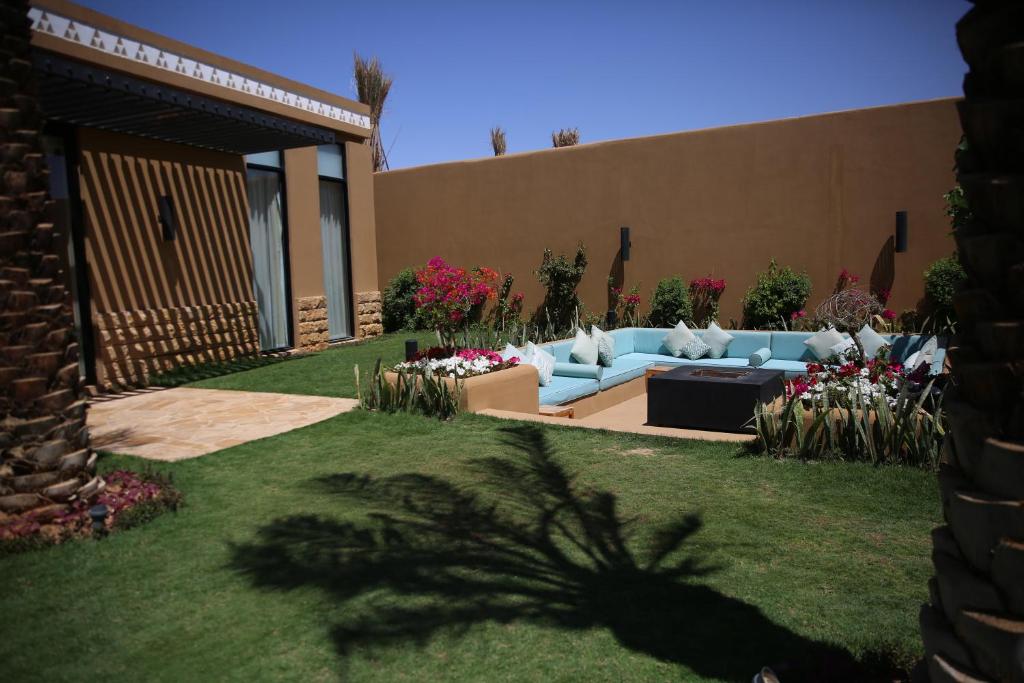 Aseel Resort في الرياض: حديقة بها أريكة زرقاء في ساحة