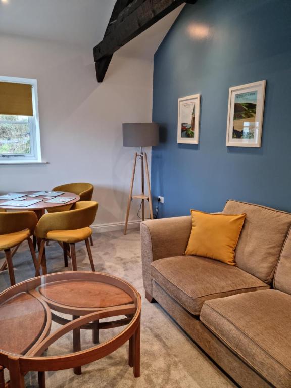 a living room with a couch and a table at The Coach house, onsite free parking in Ilfracombe