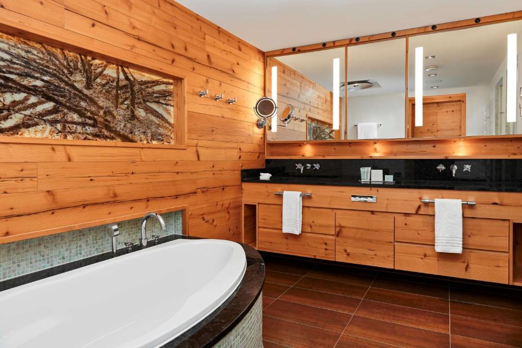 a bathroom with a tub and a wooden wall at Grand Tirolia Kitzbühel - Member of Hommage Luxury Hotels Collection in Kitzbühel