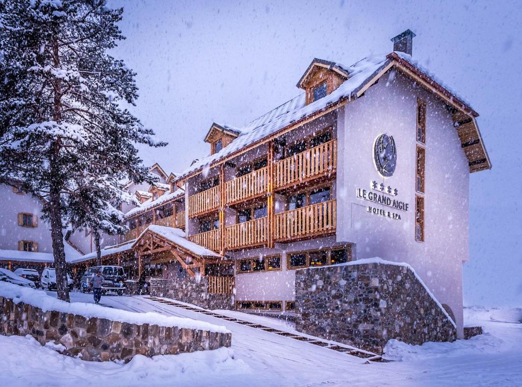 a large lodge in the snow with snow covered trees at Le Grand Aigle Hotel & Spa**** in La Salle-les-Alpes