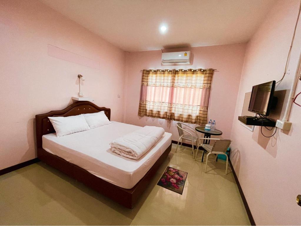 1 dormitorio con 1 cama, TV y mesa en เกาะลิบงซันไรส์ โฮมสเตย์ Koh libong sunrise Homestay en Ko Libong