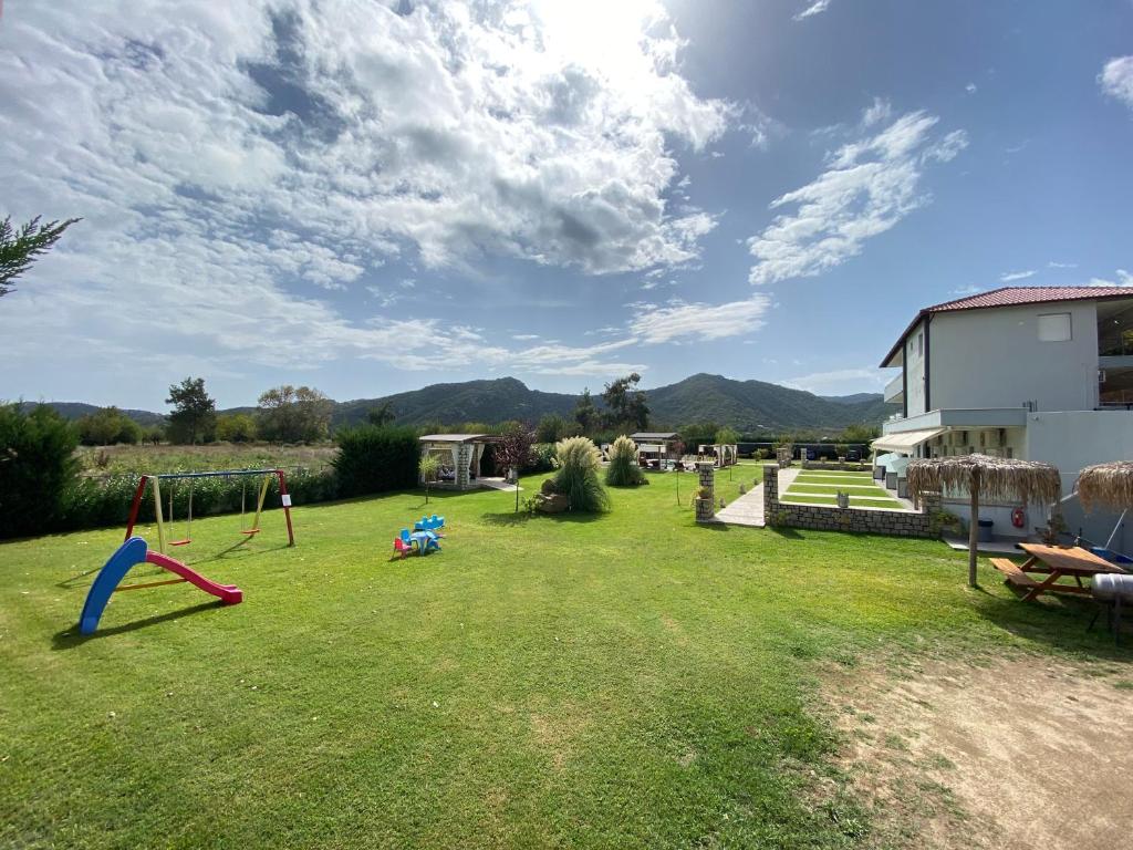 a yard with a swing set in the grass at A Ponte Studios & Apartments in Sykia Chalkidikis