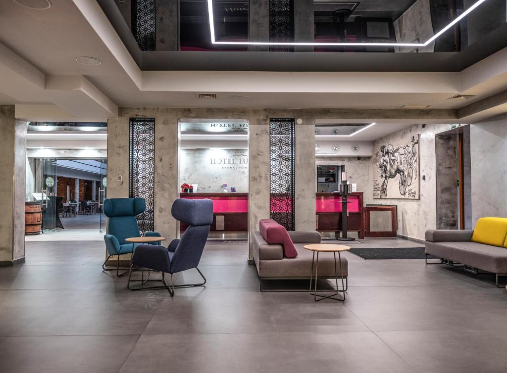 a lobby with chairs and tables in a building at Hotel Europa Starachowice in Starachowice