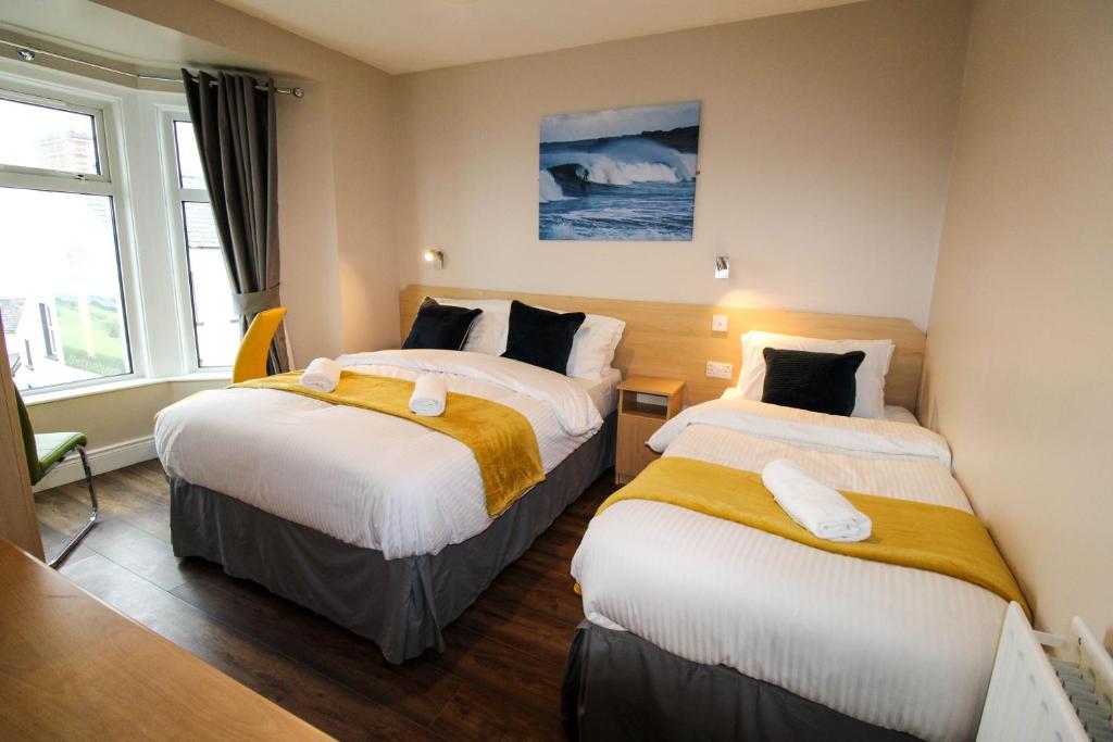 a hotel room with two beds and a window at Beulah Guest House in Portrush