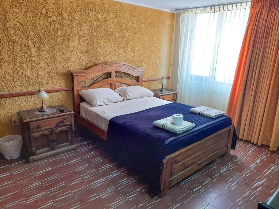Schlafzimmer mit einem Bett mit blauer Decke in der Unterkunft Depto Grande con terraza, la mejor ubicación in Tarija