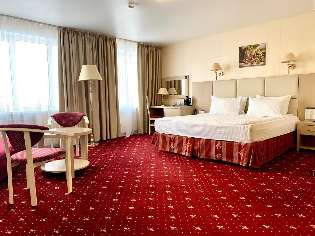 ein Hotelzimmer mit einem Bett und einem roten Teppich in der Unterkunft AMAKS City Hotel in Krasnojarsk