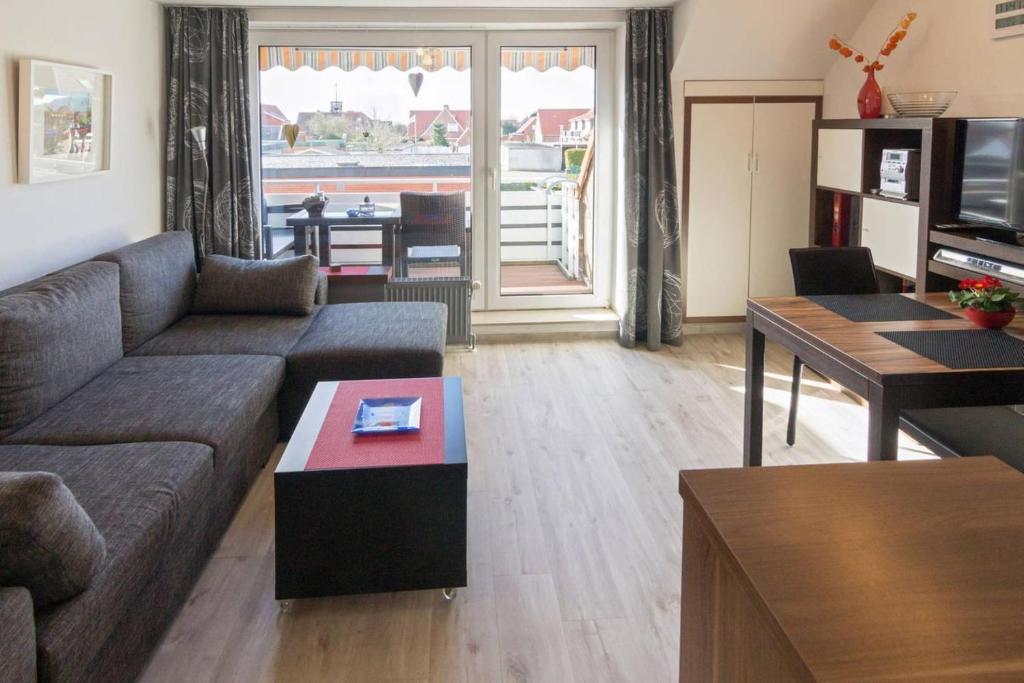 ein Wohnzimmer mit Sofa und Tisch in der Unterkunft Ferienwohnung Likedeelers in Norddeich