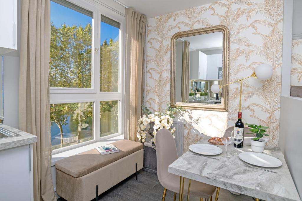 a dining room with a table and a mirror at Le Lac d&#39;Or - Duke Housing in Créteil