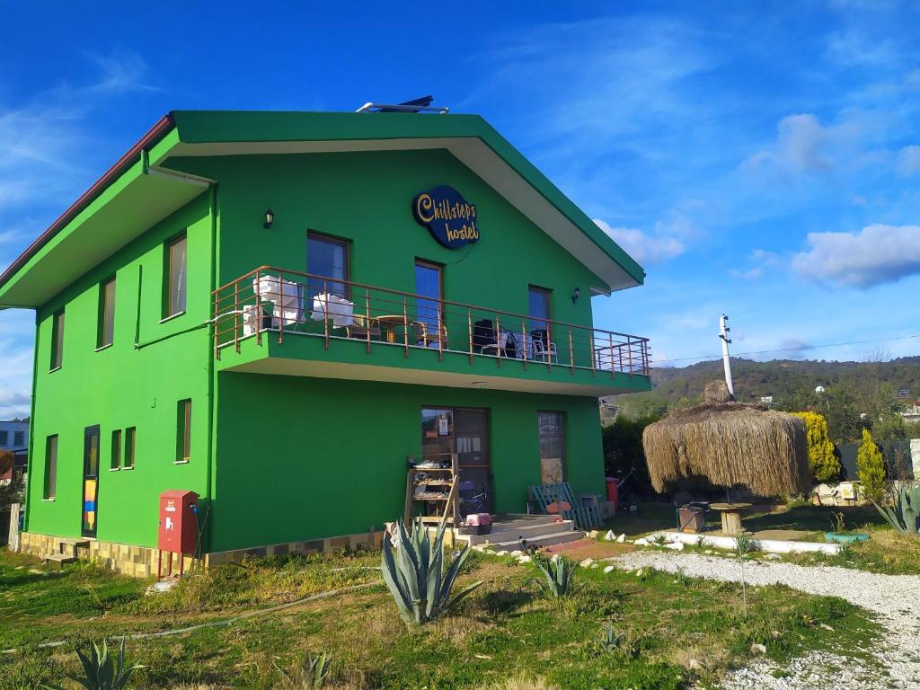 ein grünes Gebäude mit einem Schild darauf in der Unterkunft Chillsteps Hostel in Fethiye