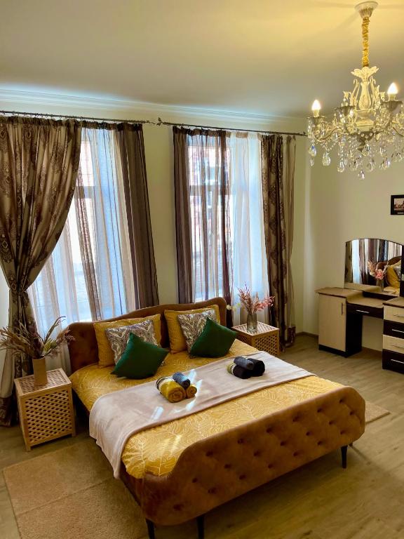 a bedroom with a large bed and a chandelier at В САМОМУ ЦЕНТРІ МІСТА, ЗДАЮТЬСЯ В ПОДОБОВУ ОРЕНДУ, АПАРТАМЕНТИ ZONEofCOMFORT in Chernivtsi
