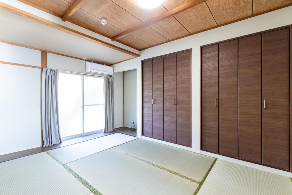 una stanza vuota con porte in legno e finestra di Keiko"s Home 宮浦一日一組限定海の絶景オーシャンビューのラグジュアリー別荘2000m2BBQ可海釣公園 a Fukuoka