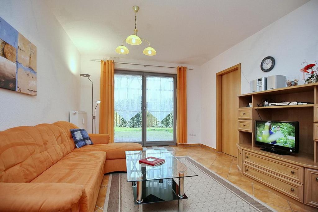 sala de estar con sofá y TV en Hanse-Hof Wohnung 05, en Boltenhagen