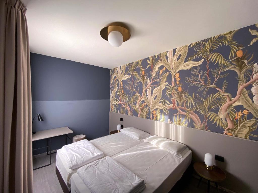 ガルダにあるHotel Astoriaのベッドルーム1室(ベッド1台付)が備わります。壁に壁画が飾られています。
