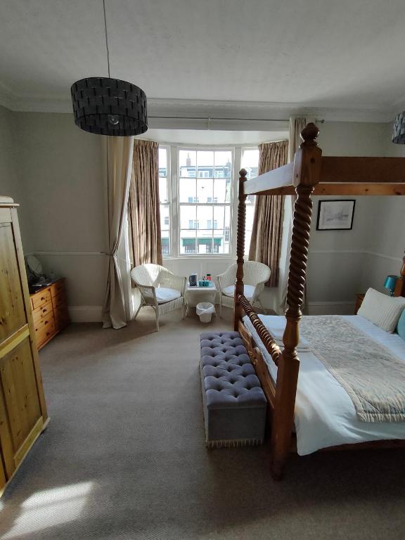 a bedroom with a canopy bed and a living room at Valentine Guest House in Weymouth