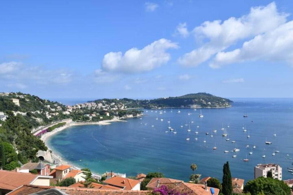 a view of a beach with boats in the water at French Riviera - 3 pièces, vue mer et piscine in Villefranche-sur-Mer