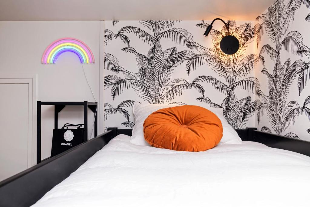 a orange pillow sitting on top of a bed at The Creteil Shelter - Duke Housing in Créteil