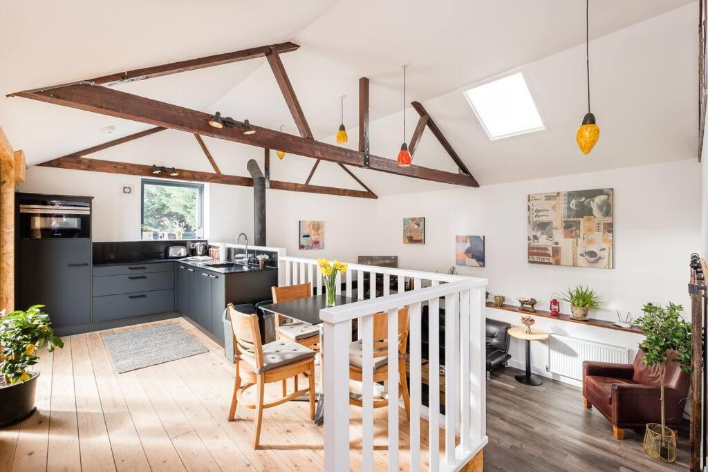 a kitchen and living room with a table and chairs at The Cider House in Sutton