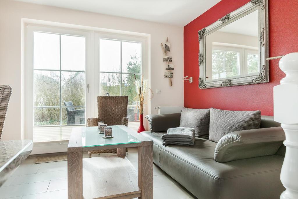 Una sala de estar con un sofá y un espejo. en Feriendomizil App 1, en Wenningstedt
