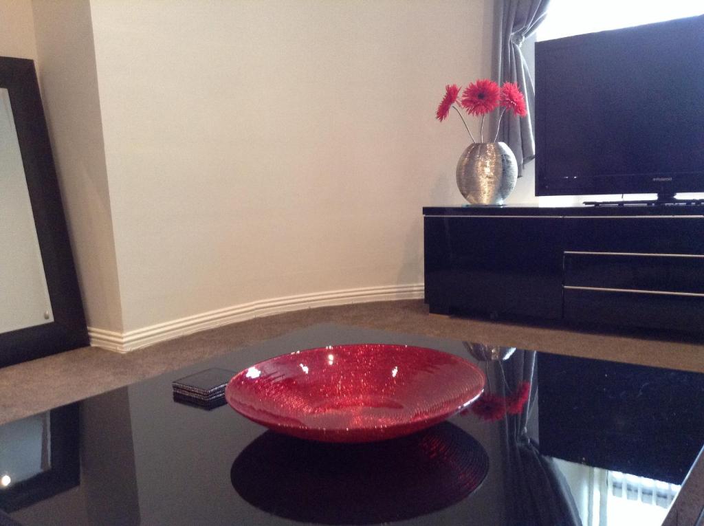 a red stool sitting on top of a table at Mode Apartments in Aberdeen