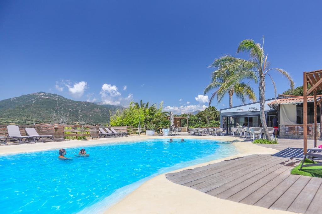een zwembad in een resort met mensen in het water bij Camping maeva Escapades Le Colomba in Olmeto