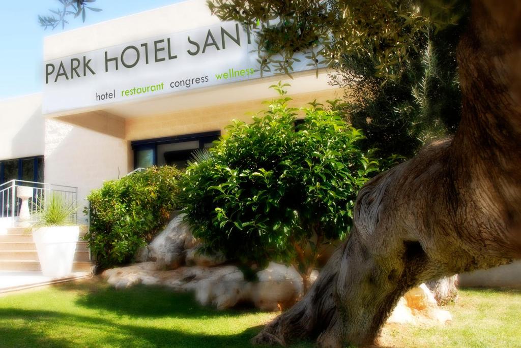 a building with a tree in front of a building at Park Hotel Sant'Elia in Fasano