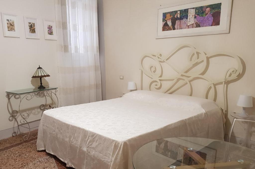 a bedroom with a white bed and a window at Relais Pacinotti Rooms in Pisa