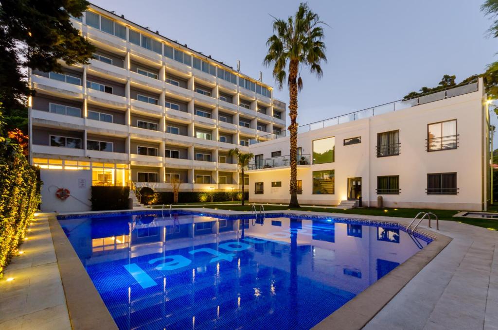 um hotel com piscina em frente a um edifício em Hotel Lido em Estoril