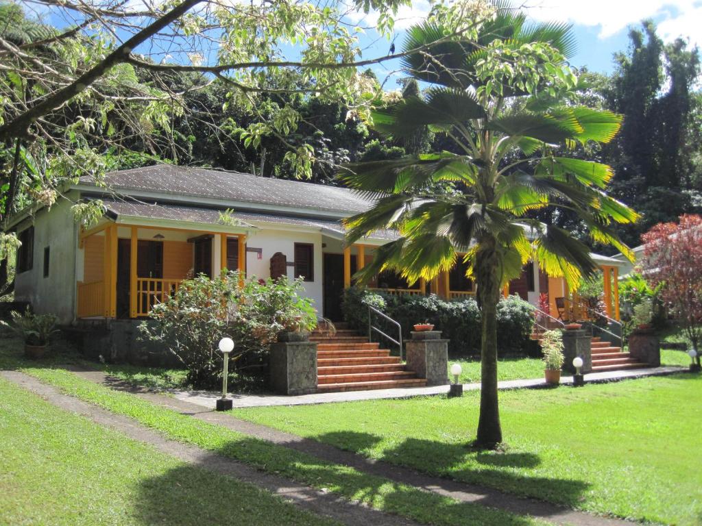 una casa con una palmera en el patio en Les Cycas en Saint-Claude