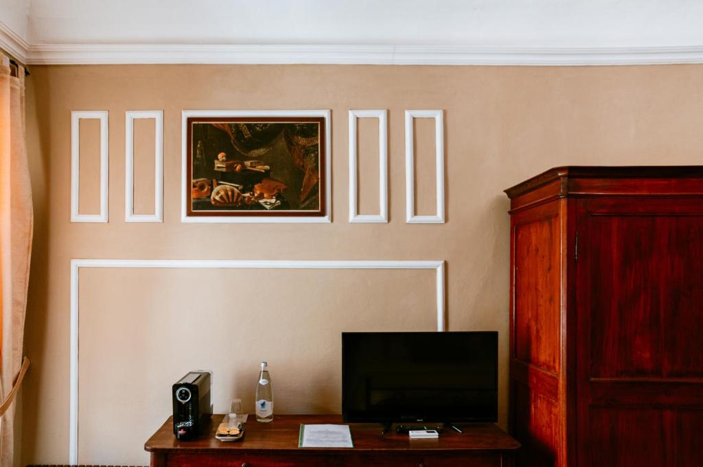 salon z telewizorem i drewnianym stołem w obiekcie La Foresteria di Palazzo Picedi Benettini w mieście Sarzana
