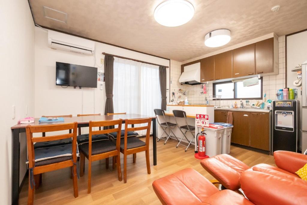 a kitchen and dining room with a table and chairs at ゲストハウスOneWorld Toji東寺 in Kyoto
