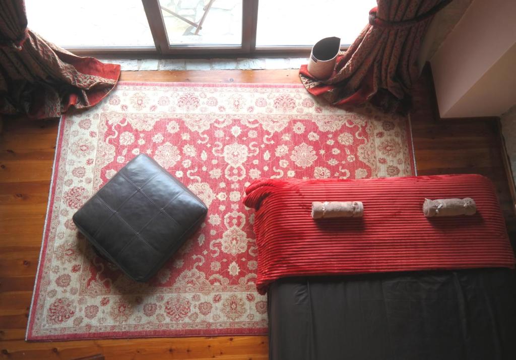 um tapete vermelho com uma bolsa em cima em Petradi Residence @ Agoriani-Parnassus em Eptalofos