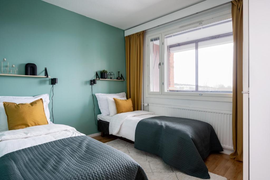1 dormitorio con 2 camas y ventana en 2 Bedroom apartment with free parking, en Kuopio