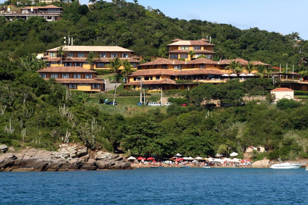 a resort on a hill next to a body of water at Colonna Galapagos Garden Hotel in Búzios