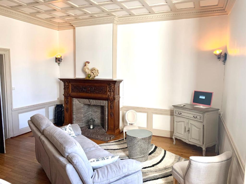 a living room with a couch and a fireplace at Le Relais Dunois de Napoléon in Châteaudun