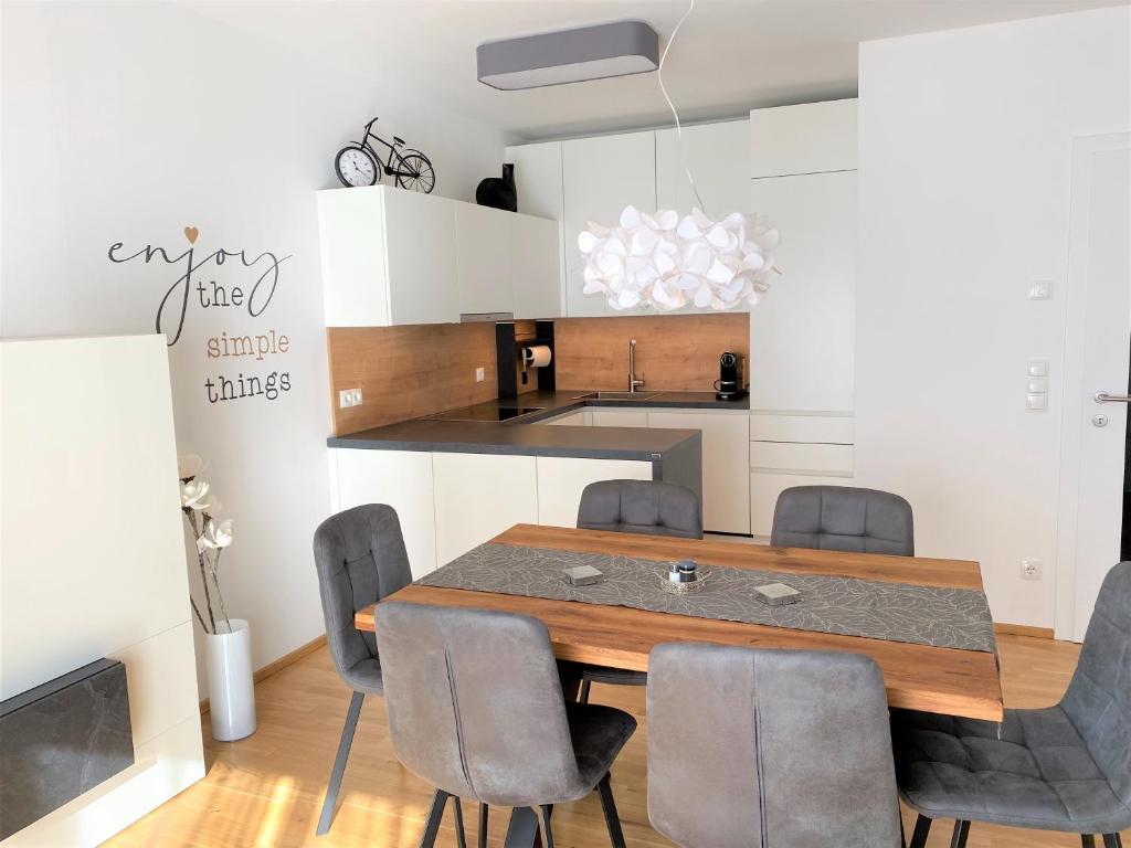 a kitchen with a dining room table and chairs at Wein Kultur Apartment Flavia Solva in Wagna